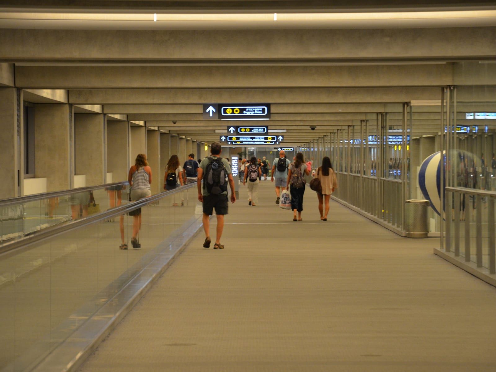 נוסעים שנחתו הולכים לכיוון אולם המזוודות בנתב"ג.